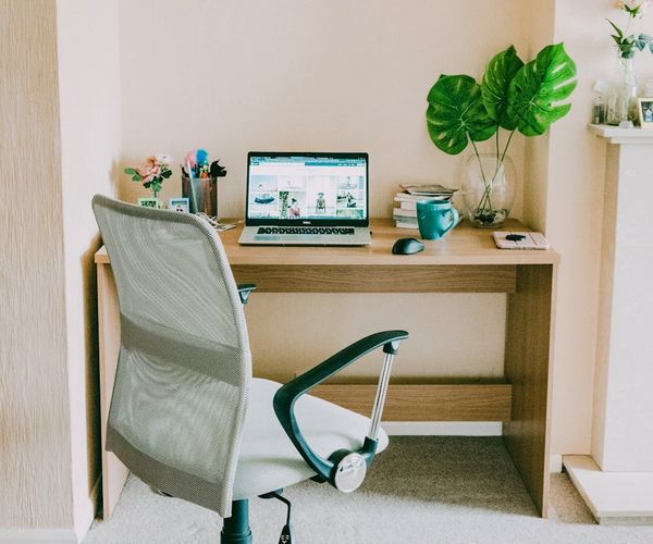 An ergonomic and clean workspace with a laptop and a comfortable chair.